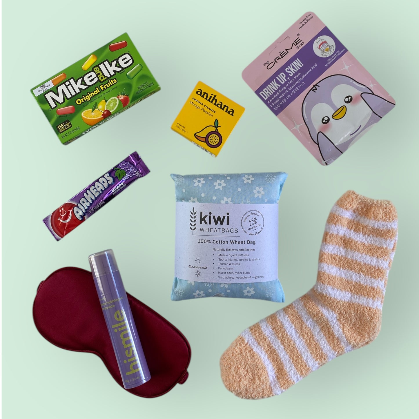 Contents of our self care gift box, american candy, anihana shower steamer, the creme shop face mask, kiwi wheat bag, hismile toothpaste, silk eye mask and fluffy socks.