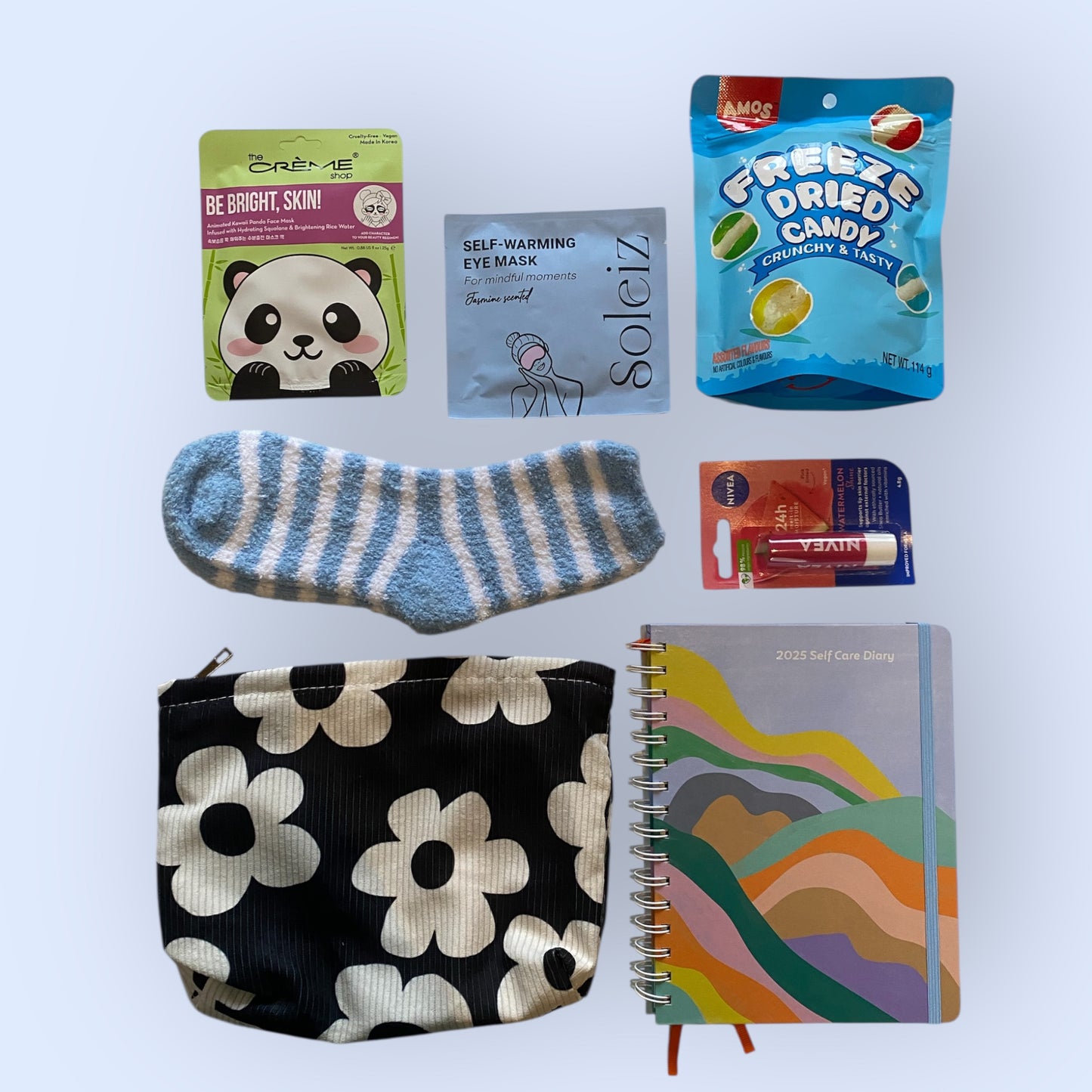 Face mask, Soleiz eye warming mask, Freee dried candy bag, fluffy socks, lip balm, toilet bag and self care diary.