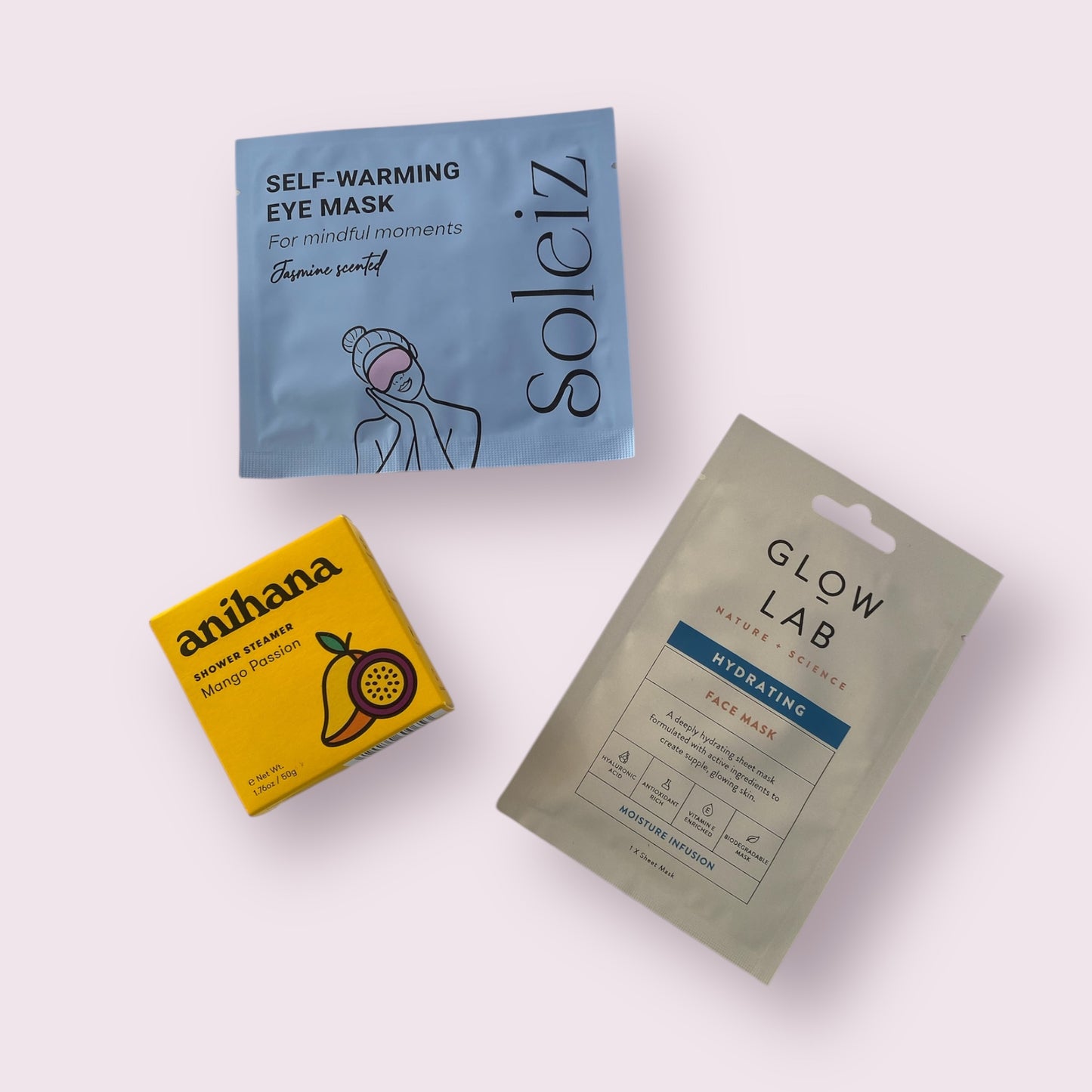 3 of the contents in our self care gift box, soleiz eye mask, anihana shower stemer and glow lab face mask.