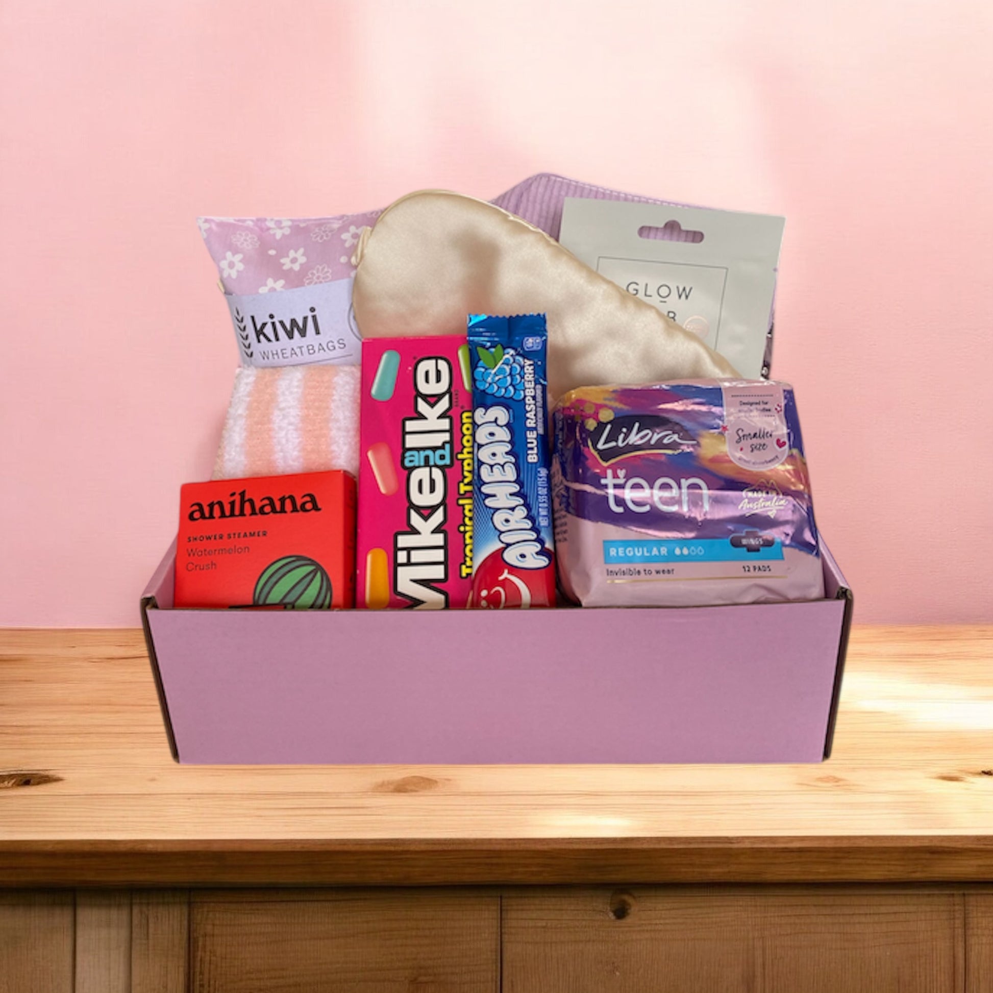 Gift box with pampering self care items in in. Wheat bag, fluffy socks, face mask, shower steamer and pads 
