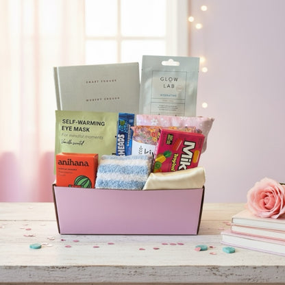 Gift box full of pamper treats. Fluffy socks, shower steamer, wheat bag, gratitude journal, American treat. 