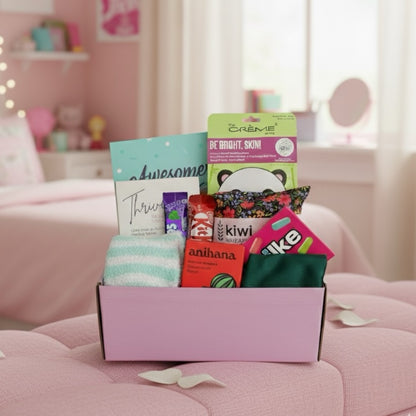 Gift Box shocasing items. Awesome ends in me gratitude journal, Thrive wellness cards, Jolly rancher candy,kiwi wheat bag, glow lab face mask, kit kat , air heads candy, eye mask, fluffy socks and anihana shower steamer.